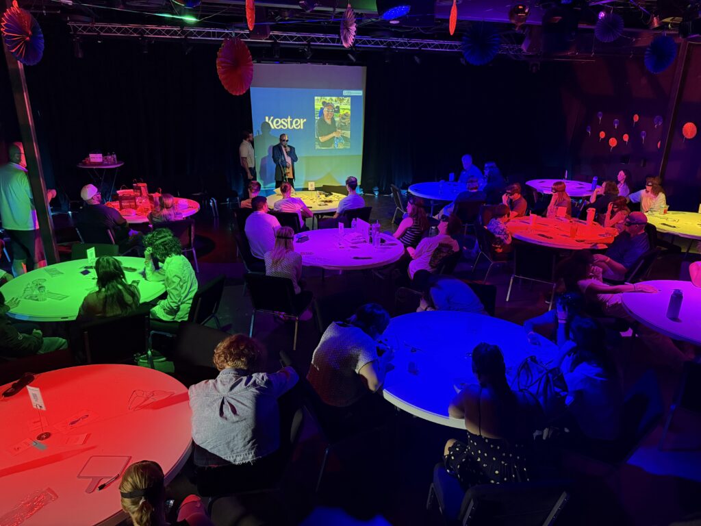 Audience seated at neon-lit community event.